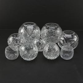 Assortment of Glass Rose Bowls: An assortment of glass rose bowls. The assortment includes seven spherical bowls in a variety of sizes with different designs cut into the sides. Also included in the lot are two small votive holders with a crackled glass design.