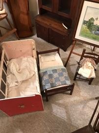 Vintage and antique doll beds, with an antique child's rush bottom chair.