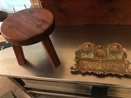 Clash of cultures:  handmade milking stool and a rococo  brass desk set.