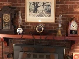 Clocks,antique kerosene lamps including one with a Delft base, a set of wright iron tongs.