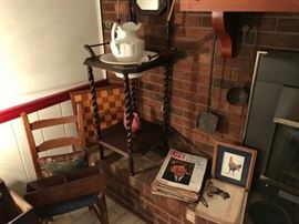 Rush bottom chair, wash stand with bowl and pitcher, vintage magazines and a pottery rooster trying to hide.