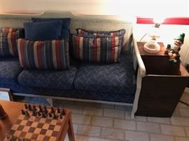 Antique wooden vegetable bin with vintage sofa and a hand made wooden chess set.