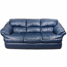 Leather Sofa: A leather sofa. This blue leather sofa features a pillow back and curved armrests flanking three seat cushions over a deep apron. A manufacturer’s tag is located under the seat cushions.