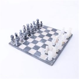 Agate and Marble Chess Set: An agate and marble chess set. This chess set features one set of chess pieces fashioned from grey and black marble and one set of chess pieces fashioned from white banded agate with a playing board fashioned from alternating squares of marble and agate. The set is unmarked.