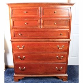 Chest on Chest of Drawers by Sumter Cabinet Company: A chest on chest of drawers by Sumter Cabinet Company. It has a beveled cornice, waist, and base, on ogee bracket feet. The top portion has four small drawers and a long drawer, all with frame detail and gold knobs. The lower portion has three large drawers, each with two gold bails on circular plates. It has the Sumter mark to the inside of a drawer. 
Matching dresser with mirror is item 17CLE067-096.