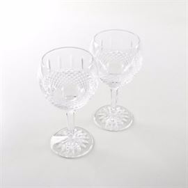Waterford "Glenmede" Balloon Wine Glasses: A pair of Waterford Glenmede crystal balloon wine glasses. Each oversized goblet bears a starburst design to the base and a faceted stem. The bowl boasts a band of bantam cross-hatches and vertical cuts. Each piece is marked with the Waterford seahorse logo to the underside.