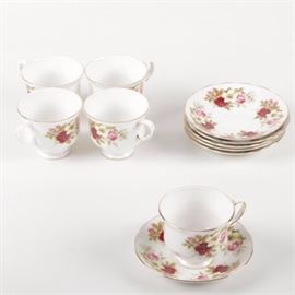 Vintage Ridgway "Queen Anne" Teacups and Saucers: A set of Ridgway Potteries vintage bone china in the Queen Anne pattern. It includes five teacups and six saucers. Each piece is decorated with pink, red, and white floral motifs against white backgrounds accented in gilt trim. They are marked to the underside, “Bone China, Queen Anne, Made in England, A Product of Ridgway Potteries Ltd”.