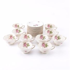 Syracuse "Victoria" Tea Set: A Syracuse porcelain tea set in the Victoria pattern. Each piece features a federal shape and are decorated with pink floral motifs against white background accented in gold trim. It includes twelve saucers and ten teacups. They are marked to the underside, “Federal Shape, Syracuse China, Made in America”.