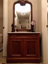 Very nice Victorian marble-topped chest, with antique mahogany mirror and rose-pink wrought iron table lamp.