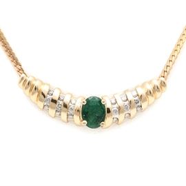 14K Yellow Gold 1.06 CT Emerald and Diamond Necklace: A 14K yellow gold emerald and diamond necklace. This necklace showcases a curved bar with the focal point being a 1.06 ct emerald. The bar is accented with rows of diamond and is suspended from a 14K yellow gold herringbone chain necklace.