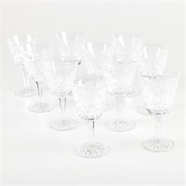 Waterford Crystal "Lismore" Goblets: A set of ten Waterford Crystal goblets in the Lismore pattern. Each piece is decorated with cross-hatch and vertical cuts to the bowl. They feature multisided stems and round bases decorated with starburst motifs. Each piece is etched “Waterford” to the underside.