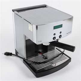 Nespresso Espresso Machine: A Nespresso Espresso machine. This espresso machine is model number D300. Features include a gray and chrome finish with steam wand, water reservoir and cup warming plates. This espresso machine also features pre-set buttons for single or double shots.