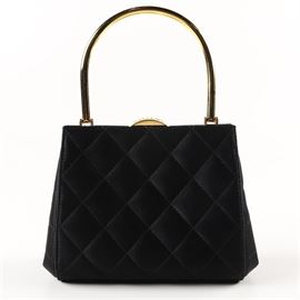 1990s Chanel Quilted Satin Mini Frame Bag: A 1990s Chanel quilted satin mini frame bag This diamond quilted, black satin bag features a hinged gold tone top handle and gold tone hinged frame with clasp closure embossed “Chanel”. The interior is lined in a black leather with sidewall zipper pocket with CC zipper pull. The leather is stamped “Chanel Made In Italy” and has hologram sticker attached to interior pocket with serial number 5478383. A black Dolce & Gabbana dust bag is included.