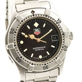 TAG Heuer Stainless Steel Wristwatch: A TAG Heuer wristwatch featuring a oyster link bracelet fastened by a fold over deployment clasp. This wristwatch showcases a count-up bezel with a 0-60 scale. The dial features hour index markers with luminous style watch hands and a date window positioned at the three o’ clock.