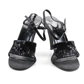 Gucci Embellished Heeled Sandals: A pair of women’s Gucci heeled sandals in size 7 B. These black heels feature open square-toes, wide vamp straps that are embellished with seed beads, thin ankle straps with silver tone buckle closures, leather insoles stamped “Gucci made in Italy” and stacked stiletto heels. The black leather soles are stamped “Gucci made in Italy 7 B”.