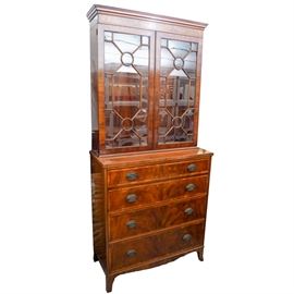 19th-Century Federal Mahogany Secretary: A late 19th-century Federal mahogany secretary. The secretary features crown molding along the top of the recessed upper cabinet. The cabinet has divided glass panes with bead trim. The interior of the cabinet has holes and pegs along the sides hold shelves (shelves are missing). The lower section has a hinged, faux drawer front, whichfolds down to form the desktop. The desk interior houses divided compartments, drawers and a small locking cabinet. The desktop is covered with red leather which has gold stamped borders. . Below are two dovetailed drawers. The drawers are fitted with oval Federal style pulls in aged brass, and the secretary rests on French-style splay feet. The secretary has a metal tag on the inside of a drawer which is marked “Wm. A. Berkey Furniture Co. Est. 1881 – W.A.B. F. Co.”