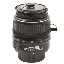 Nikon AF-S DX Nikkor 18-55mm II Zoom Lens: A Nikon 18-55mm AF-S II zoom lens, serial number US6410687. The piece is marked “Nikon DX AF-S Nikkor 18-55mm 1:3.5-5.6G II ED” to one side. It is marked “DX SWM ED Aspherical 0.25m/0.92ft, Made in Thailand” to the other side and includes an attached lens cap.