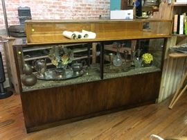 The smaller top case is 66" wide x 8" high x 24" deep. It has glass top and back opens by drop down.  The lower case is 72" wide x 40" high x 21" deep.  Glass back doors slide open.  Open storage below.