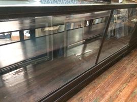 94" wide x 42" high x 25" deep.  Glass back doors slide open.  3 staggered depth shelves inside.