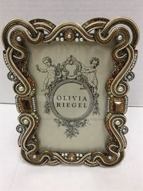 Olivia Riegel Baronessa Swarovski Crystal and Moire Silk Photo Frame
From the Baronessa Collection, this cast pewter photo frame in antiqued brass finish is accentuated with hand-set Swarovski crystal and faux pearls.

• 4" X 6"