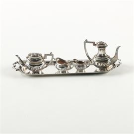 1968 A. Marston & Co. British Miniature Sterling Silver Coffee and Tea Service: A vintage miniature sterling silver coffee and tea service by A. Marston & Co. This set features five pieces, including a coffee pot, teapot, open sugar bowl, creamer, and an oval serving tray. These pieces feature handled sides with pointed handles. The undersides are stamped, “AM & Co.” along with Birmingham hallmarks representing an anchor, lion passant, and a “T” for 1968. The total approximate weight is 1.895 ozt.