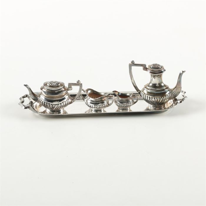 1968 A. Marston & Co. British Miniature Sterling Silver Coffee and Tea Service: A vintage miniature sterling silver coffee and tea service by A. Marston & Co. This set features five pieces, including a coffee pot, teapot, open sugar bowl, creamer, and an oval serving tray. These pieces feature handled sides with pointed handles. The undersides are stamped, “AM & Co.” along with Birmingham hallmarks representing an anchor, lion passant, and a “T” for 1968. The total approximate weight is 1.895 ozt.
