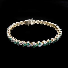 18K Yellow Gold Emerald and Diamond Tennis Bracelet: A 18K yellow gold emerald and diamond tennis bracelet.