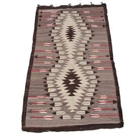 Handwoven Native American Style Wool Accent Rug: A handwoven Native American Style wool accent rug. This rug features a palette of gray, ivory, black/brown, and red; displaying two central diamond motifs, bordered in feather motifs, as well as arrows on a gray field. The field is bordered in solid black/brown, finished with bound edges and ends, offering curtain rings to one end. Unlabeled.