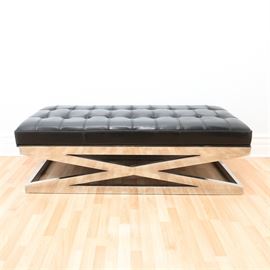 Contemporary Modern Black Leather Bench On Stainless Steel Base: A contemporary Modern black leather bench on stainless steel base. This low bench or long foot stool has a dramatic X form stainless steel design on a square base with the black leather button tufted upholstered seat being comprised of three rows of ten welted squares on a raised cushion. Unmarked.