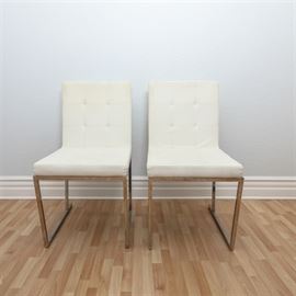 Pair of Contemporary Side Chairs: A pair of contemporary side chairs. These chairs feature a square back over a square seat, each with button tufting, that rise above square metal legs that are connected by a low stretcher. The chairs are unmarked.