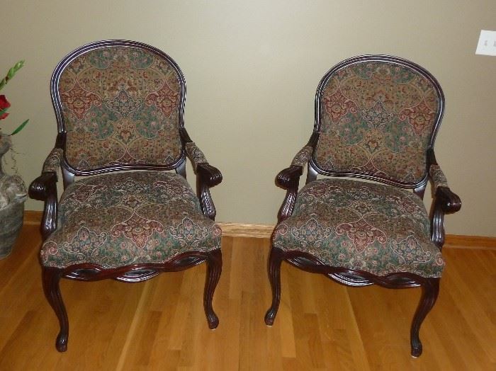 Pair of carved wood arm chairs with upholstered seats and backs.  26" wide, 42" tall