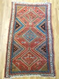 Vintage Persian tribal rug, 100% wool, hand woven, measures 5' x 7'.