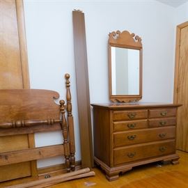 Maple American Colonial Style Two-Piece Bedroom Set by Roger Conant Group: A two piece American Colonial style bedroom set by Roger Conant Group. The cannonball bed frame has ball finials at the top of the vase and ring posts, which end on turnip feet; the headboard has curved ears and the footboard has a turned rail between the posts. It comes with plain side rails and support slats. The dresser has a removable mirror in a wooden frame with curled pediment and base. It has four small drawers over two large drawers, all with bails on batwing plates, and raised on a beveled base with ogee bracket feet. The maker’s tag is to the inside of a drawer.