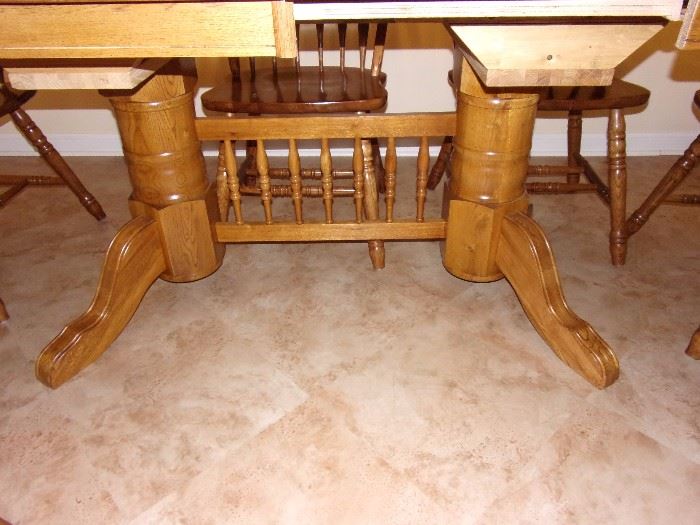 Furnish your dining room with a durable and long lasting rectangular dining table. The table has an elegant trestle base and beautiful scalloped edges for a traditional American style. It's made completely out of solid oak, making the base extremely strong and durable. Features of this table include rounded edges, brass leaf alignment pins, heavy duty brass sash locks, and the dual ball bearing cable glide extension mechanism for a smooth operation. Also included are two 18 inch  leaves that expand to accommodate eight guests comfortably. 4 side chairs and 2 arm/captain chairs.
