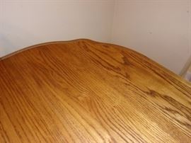 Furnish your dining room with a durable and long lasting rectangular dining table. The table has an elegant trestle base and beautiful scalloped edges for a traditional American style. It's made completely out of solid oak, making the base extremely strong and durable. Features of this table include rounded edges, brass leaf alignment pins, heavy duty brass sash locks, and the dual ball bearing cable glide extension mechanism for a smooth operation. Also included are two 18 inch  leaves that expand to accommodate eight guests comfortably. 4 side chairs and 2 arm/captain chairs.