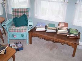 ANOTHER WICKER CHAIR, MAHOGANY COFFEE TABLE & BOOKS