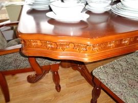 shot of the carving on the dining table, has 8 chairs