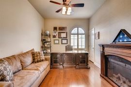 Couch, beautiful like new desk and chair, fireplace, shelving unit, artwork.