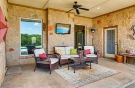 Patio chairs and love seat, flat screen tv, patio decor.
