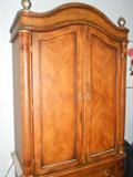 Master bedroom armoire with king size sleigh bed, triple dresser and end tables.