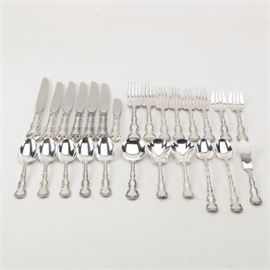 Gorham "Strasbourg" Sterling Flatware Set: A set of sterling silver flatware by Gorham. This is in the William C. Codman designed Strasbourg pattern, first introduced in 1897, which features a scroll bordered handle with shell accented tip. The twenty-six piece set includes two dinner forks, four place forks, two salad forks, five teaspoons, a soup spoon, two sugar spoons, two iced tea spoons, and a master butter knife, all marked “Gorham Sterling” to the backs. They are presented with a large dinner knife, five smaller dinner knives, and a butter spreader with stainless blades and sterling handles. The total approximate weight, excluding the dinner knives and butter spreader with stainless blades, is 25.870 ozt.