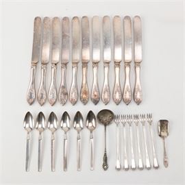 1847 Rogers "Old Colony" Silver Plate Knives with Other Silver Plate Flatware: An assortment of 1847 Rogers knives in the Old Colony pattern with an assortment of silver plate flatware. This includes eleven 1847 Rogers dinner knives in the Old Colony pattern featuring handles with a floral design and pierced tips. These are presented with six Community Plate Twilight spoons featuring pointed bowls and volute fluting at the beginning of the handle, six Continental 1886 Silver Plate pickle forks in the Continental Three pattern with plumes at the tip with arabesque accents, a gravy ladle by the Stratford Silver Company in the Rosedale pattern that was first introduced in 1913 and features a repoussé rose design on the handle and an EPNS sugar spoon with simple pointed tip.