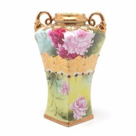 Nippon Hand-Painted Vase: A Nippon Vase. This hand-painted Nippon vase features a floral motif and Asian inspired geometric designs. The handles and mouth of the vase are gilded as well as the geometric design on the body and the vase is marked with green maple leaf Nippon stamp, circa 1891.