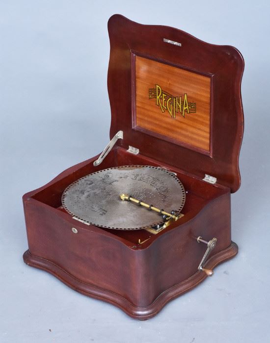 Regina Disk Music Box	
serpentine case, playing 15 1/2" disks, 
step-down bed with double comb,
19 1/2" wide x 12" high x 21" deep 
with 16 disks, circa 1900    Bid on-line November 10th -15th at www.fairfieldauction.com