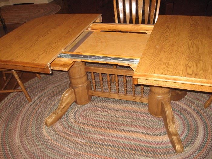 Dining Table showing the Two 18" Leaves Stored in Table,  also notice one of the Three Matching Braided Rugs...