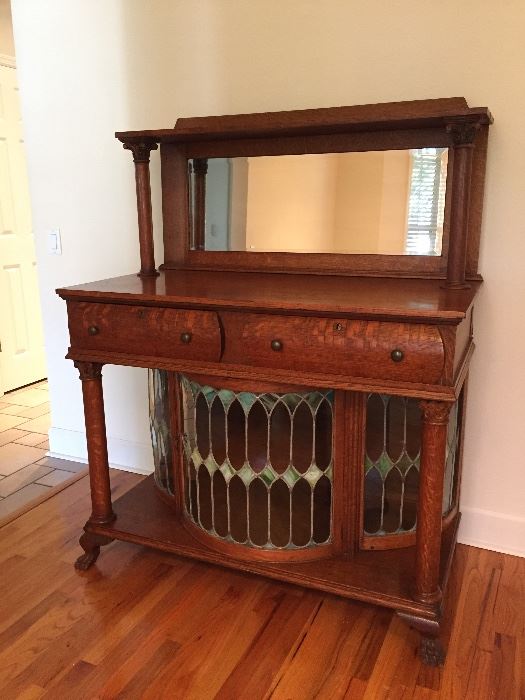 Antique oak sideboard with beveled glass mirror, curved doors with stained glass.  It’s fabulous!