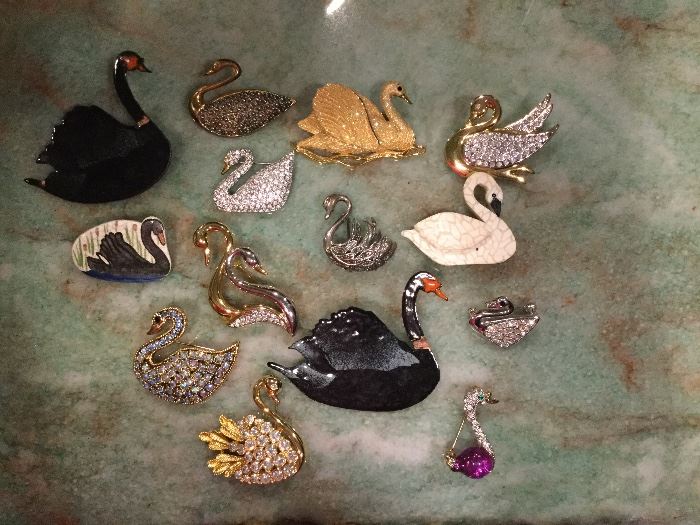 Collection of swan pins.  Rhinestones, enamel, gold wire.  Lakeland’s logo.