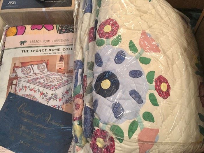 Applique quilts in original packages, including, at left, Legacy Home stained-glass quilt