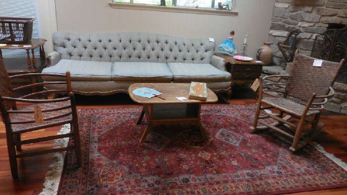 vintage couch, side tables, great looking area rug, rustic chairs one is a rocker, rustic coffee table