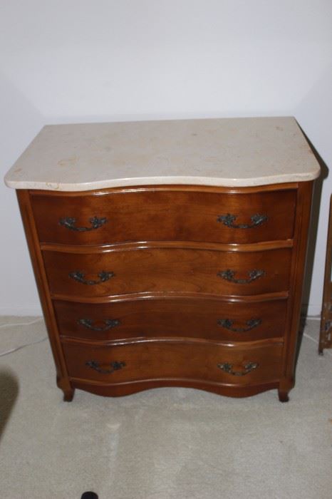 One of two matching marble top four drawer chests.